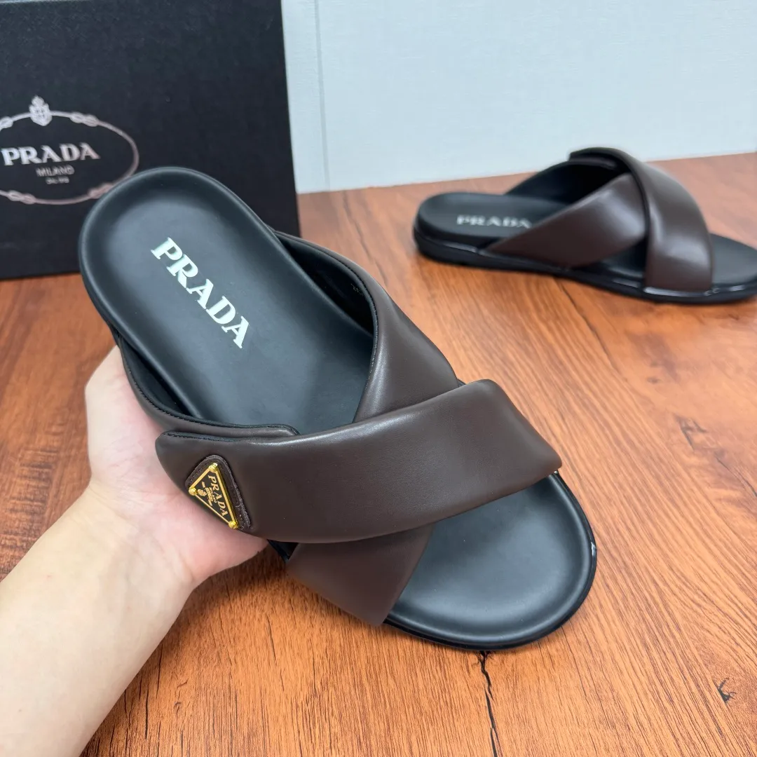 Batch 580 Prada/Prada's new men's leather cross slippers. Velcro closure can finely adjust the size. Calf leather light luxury slippers. Thick soft calf leather wraps the upper. Fat but soft rubber lazy style, soft and comfortable, excellent foot feel. Genuine leather bottom layer, cross style, with a Velcro closure buckle, easy to adjust the appropriate size, and a perfect fit for the wearing experience. The enamel gold triangle logo highlights the brand's classic features. Lightweight rubber thin sole, high foot comfort! Complete package! Size: 39-40-41-42-43-44-45 Leather shoe size Item number: 2X7132 Brown